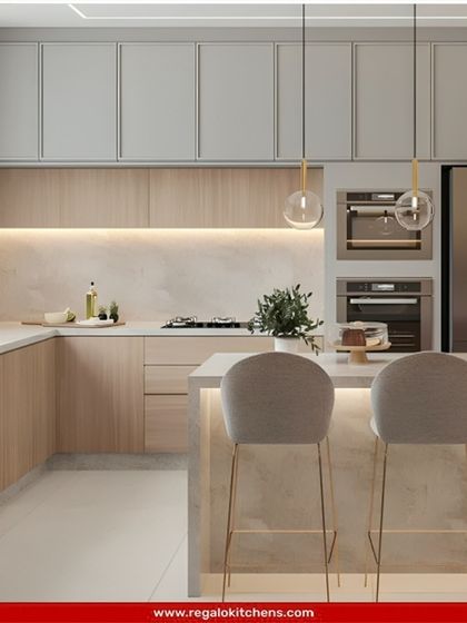 Another view of our light wood and marble island kitchen, highlighting the ample counter space and seating. We design these spaces to be both beautiful and highly functional, serving as the true heart of the home.