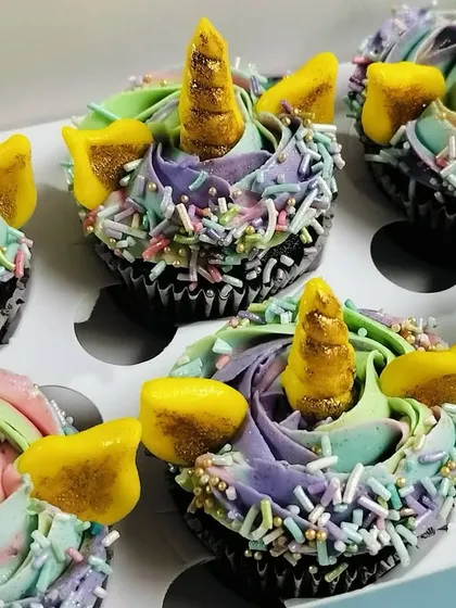 Another detailed shot of the unicorn cupcakes, highlighting the texture of the buttercream and the generous amount of pastel sprinkles. These mini cupcakes are filled with a rich chocolate ganache.