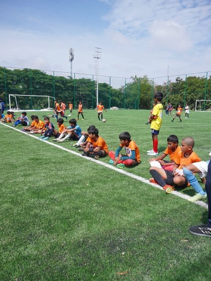 Trialists for the U12 and U14 teams sit on the sideline, watching and learning while waiting for their turn to play.