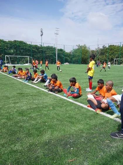 Trialists for the U12 and U14 teams sit on the sideline, watching and learning while waiting for their turn to play.