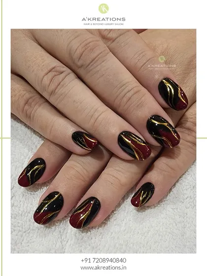 A bold and glamorous design using black and deep red polish as a base. I hand-painted elegant gold swirls over the top to create a sense of luxury and movement.