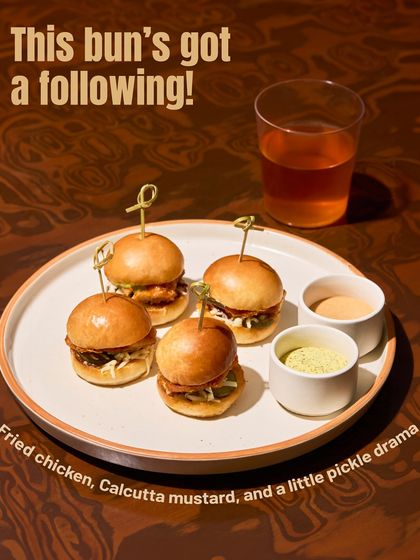 This bun has a following. Crispy fried chicken, a kick of Calcutta mustard, and some pickle drama, all in a mini bun. It's a flavour explosion.