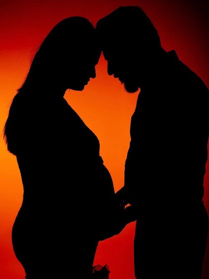 A powerful silhouette of a couple against a warm, glowing background. This artistic shot captures their connection in a dramatic and beautiful way.