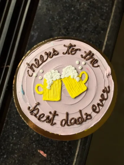 A fun cake for Father's Day or a dad's birthday, saying "cheers to the best dads ever".