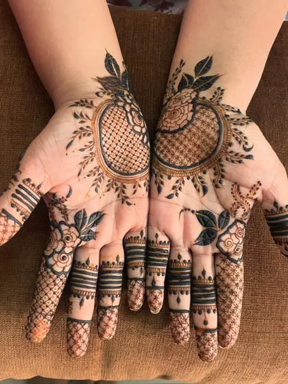 A beautiful minimal design with a central leafy mandala. The delicate vines and detailed finger work create a very chic look.