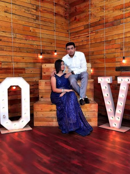 An indoor pre-wedding shoot with a 'LOVE' marquee light setup. We utilize creative studio props and lighting to produce stylish and modern couple portraits.