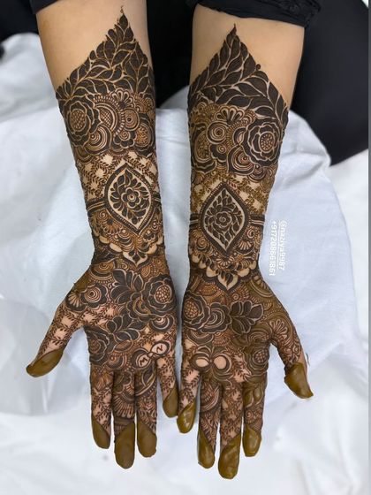 This design features a beautiful paisley motif on the wrist, surrounded by a sea of intricate floral and leaf patterns.