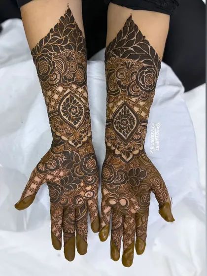 This design features a beautiful paisley motif on the wrist, surrounded by a sea of intricate floral and leaf patterns.
