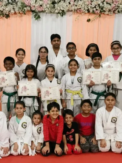The full group of achievers from our Rejoice International School program, spanning multiple belt levels.