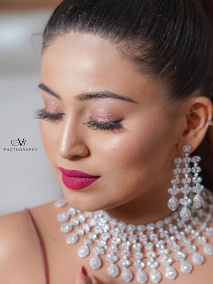 A beautiful close-up of the bride, focusing on her elegant makeup and the sparkle of her diamond necklace and earrings.