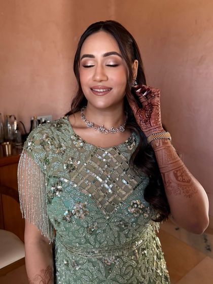 With her eyes closed, you can see the delicate shimmer on her eyelids. This soft glam eye makeup is perfect for a daytime event, adding a touch of sparkle without being overpowering.