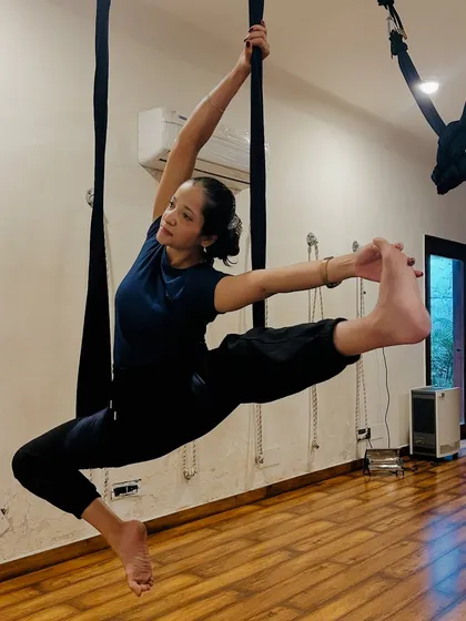 This advanced aerial pose requires significant flexibility and strength. The silk provides support to explore deeper expressions of the asana.