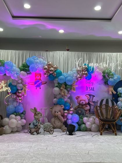 An elaborate naming ceremony decoration with a teddy bear and hot air balloon theme. This large-scale setup is perfect for a banquet hall, featuring multiple props and a wide balloon arch.