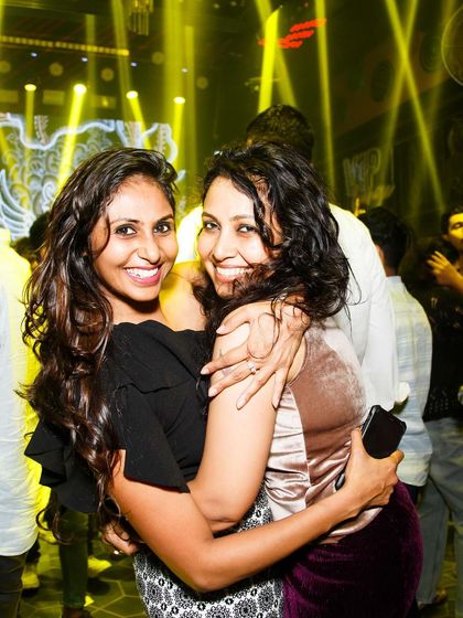 Two friends hugging and smiling.