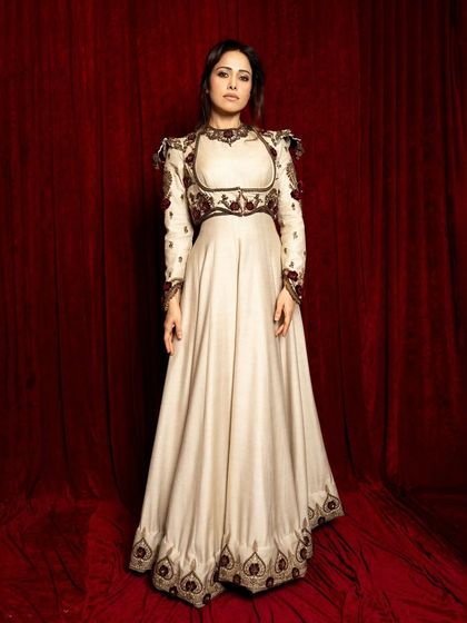 Another full-length shot against the red curtain, this pose is more centered and formal, showcasing the complete look.