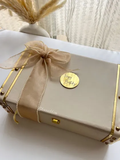 The exterior of the beige and gold luxury trunk, personalized with a 'Happy Birthday' tag. It’s all about the presentation.