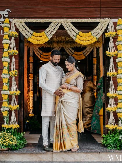 Another beautiful portrait of us at the entrance, framed by floral garlands. Our matching outfits were designed to create a lasting memory of this special day.