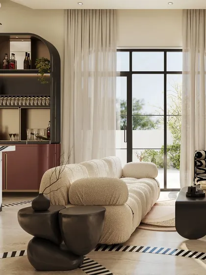 The plush, modular sofa offers a soft counterpoint to the bold, sculptural elements in the room. This view highlights the interplay of textures and forms, from the smooth, dark side tables to the soft, inviting upholstery.