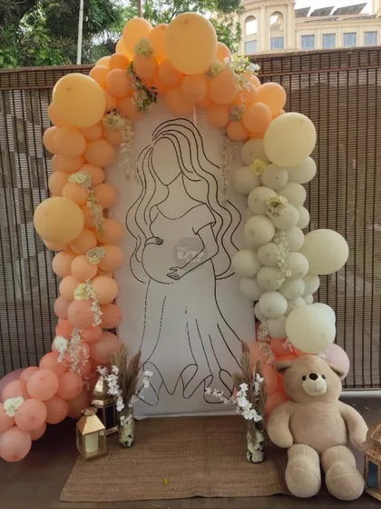 This custom backdrop is one of our favorite ways to personalize a baby shower. We created a beautiful line-art illustration of the mom-to-be, framed by a soft peach and white balloon arch and a cuddly teddy bear, making for a truly unique and sentimental photo opportunity.