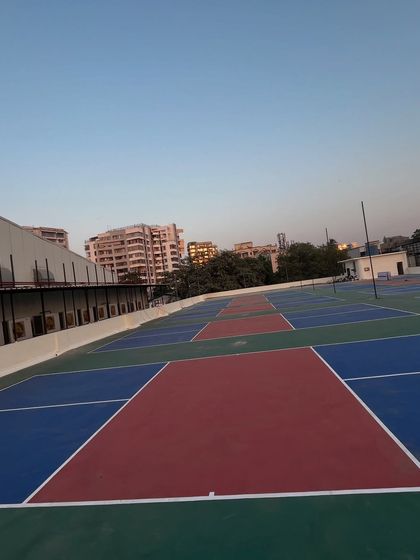 Another perspective of the terrace courts during the day, showing the open-air environment with the Mumbai skyline in the background. It's a unique urban setting for a game of pickleball.
