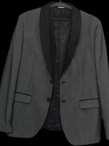 This patterned grey blazer with black satin lapels is a sharp and modern rental option. It's perfect for adding a touch of personality to a formal outfit.