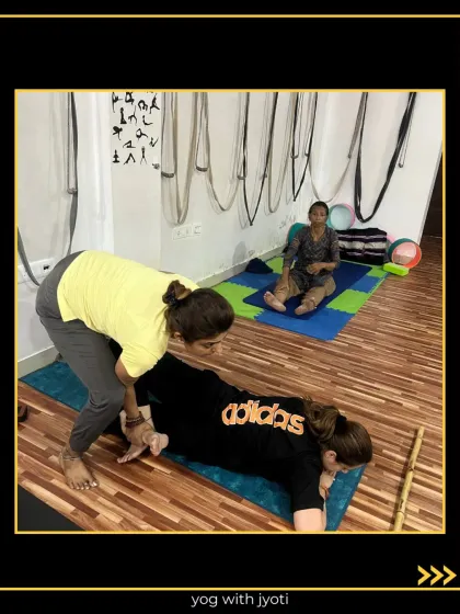 A hands-on assist for a prone twist, which helps to release the lower back and hips.