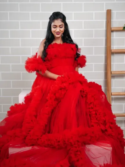Feel the drama in this incredible red ruffled tulle gown. The sheer volume and vibrant color make for an unforgettable maternity photo.