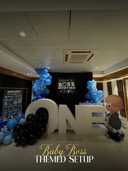Welcome to the 1st birthday of Boss Jayditya. This Boss Baby theme features a black shimmer backdrop, 'ONE' marquee letters, and character cutouts for a corporate-level celebration.