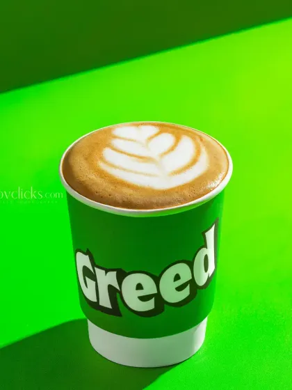 A hot cappuccino with leaf-shaped latte art, shot with strong, graphic lighting.