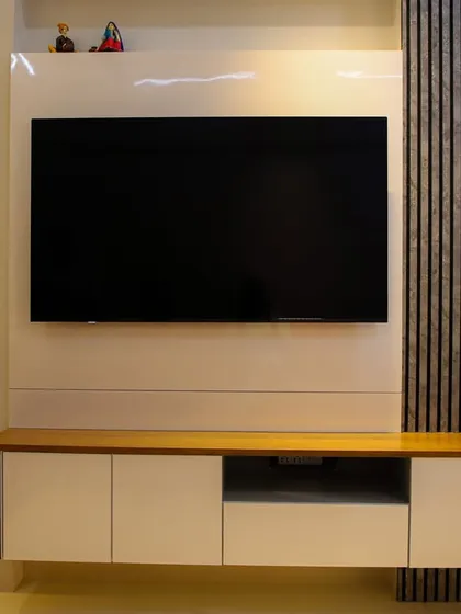 A close-up of a floating TV console featuring a stunning feather-motif bas-relief panel with backlighting, adding an artistic and delicate touch.