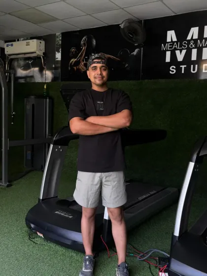 Standing by the treadmills, a core part of my cardio training.