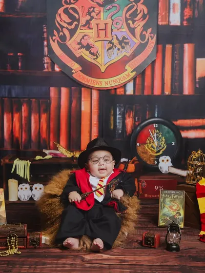 We believe in making magic. For this baby wizard photoshoot, we built a complete Hogwarts-inspired set, filled with classic books, house scarves, and a magical wand to create an enchanting portrait for this little one.