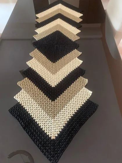 This modern chevron table runner is a real statement piece. I created this design in neutral shades of black, beige, and cream to add a touch of class to a contemporary dining or coffee table.