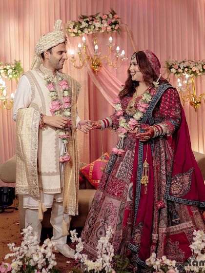 A happy, candid shot of the couple on their wedding stage, sharing a laugh and holding hands.