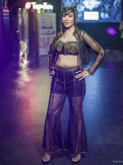 A model in a sheer black and gold ensemble with a dramatic headpiece. This shot highlights edgy, high-fashion looks for designers with a bold vision.