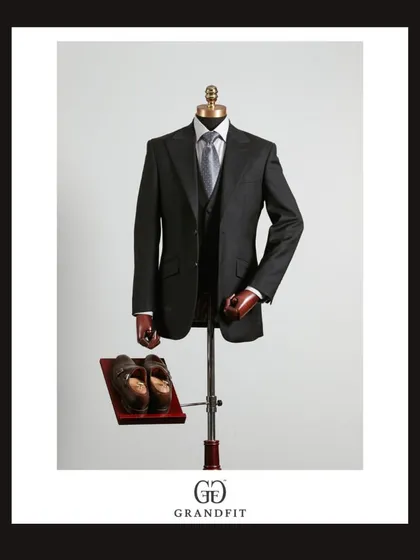 Displayed on a mannequin, the black three-piece suit's structure and drape are clearly visible, highlighting the quality of our tailoring.
