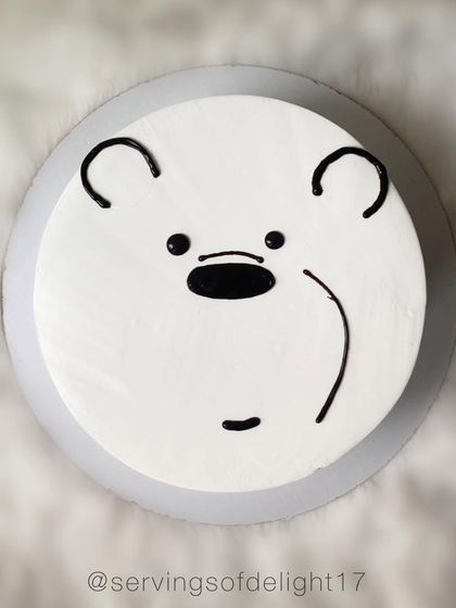 A top-down view of the Ice Bear cake, showing the simple yet recognizable hand-piped details of the character's face.