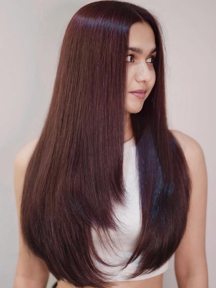 Bold and unapologetic. This sleek, long hairstyle is taken to the next level with a rich, reddish-brown global color.