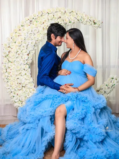 An intimate couple's portrait capturing sop a tender moment. Our studio sets, like this beautiful floral moon prop, provide the perfect romantic backdrop for celebrating your journey together.
