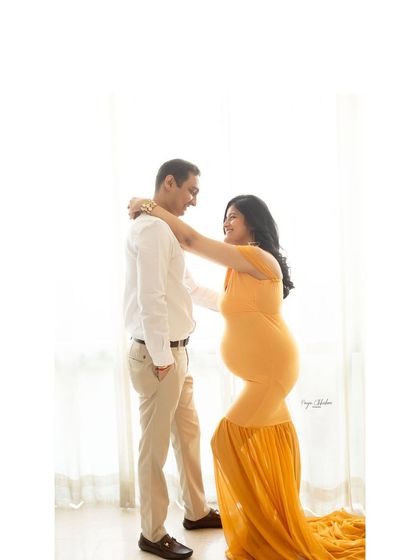 A candid moment of connection. The simple, high-key background and natural light from the window create a soft and airy feel, perfect for capturing genuine interactions.