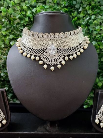 A beautiful silver-toned choker set with a mesh design and pearl drops, perfect for a sophisticated and modern look.