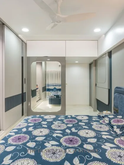 Another view of the master bedroom, showing the integrated TV unit and wardrobe with a sliding mirror panel. The design maximizes storage and function without compromising on style.