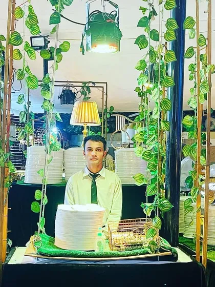 Quality is in every detail, from the food to the presentation. This green and gold setup with hanging vines creates a lush, premium atmosphere, with my staff ensuring everything is perfect.