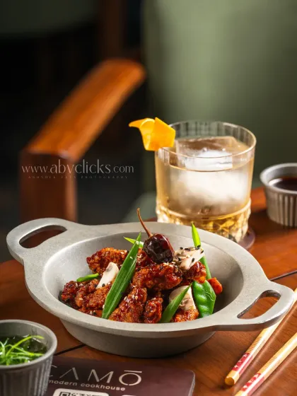 A spicy Kung Pao chicken dish from Camo, Noida, paired with a whiskey cocktail.