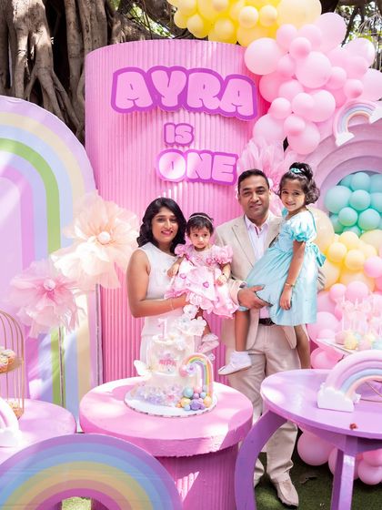 A happy family portrait at Ayra's colorful first birthday celebration.