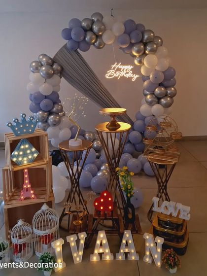 A beautiful and simple birthday setup at home. The silver and pastel blue balloon ring, combined with plenty of props, creates a full and festive look.