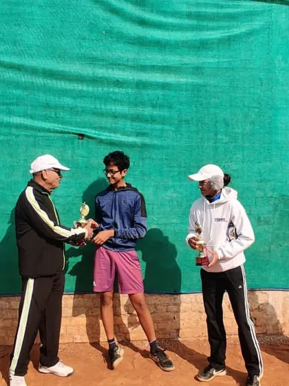 An official presenting the runner-up trophy for a doubles event. My coaching covers all aspects of the game, including doubles strategy.