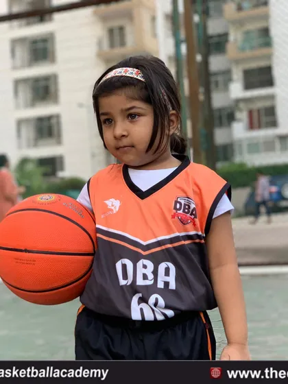 The journey begins with a single dribble. A young player in her DBA jersey, ready to learn and play.