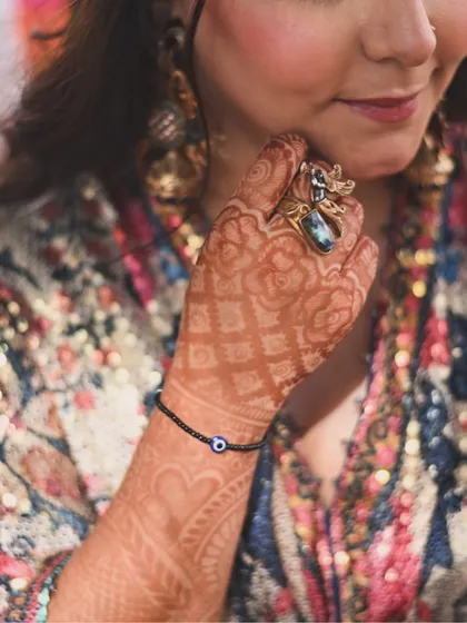 A close-up of the beautiful details for my sister's haldi and mehendi look. The intricate henna, the unique evil eye bracelet, and the statement ring from Apala by Sumit all came together to create a look that was both traditional and personal.
