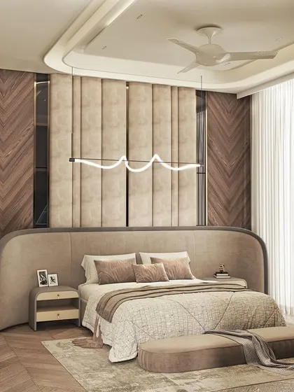 Luxury meets calm in this master bedroom, which features a curved, upholstered headboard and a stunning chevron-patterned wooden wall. A modern, wave-like light fixture hangs above the bed.